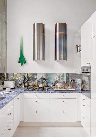 Small u-shaped kitchen with mirrored splashback