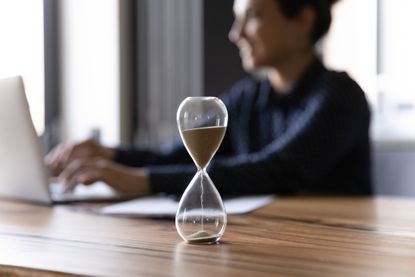 An hourglass on a office table. 