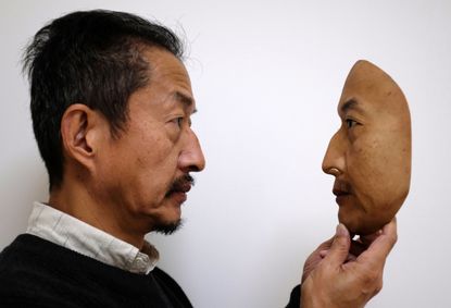 President Osamu Kitagawa holds a super-realistic face mask at his factory in Otsu, western Japan.