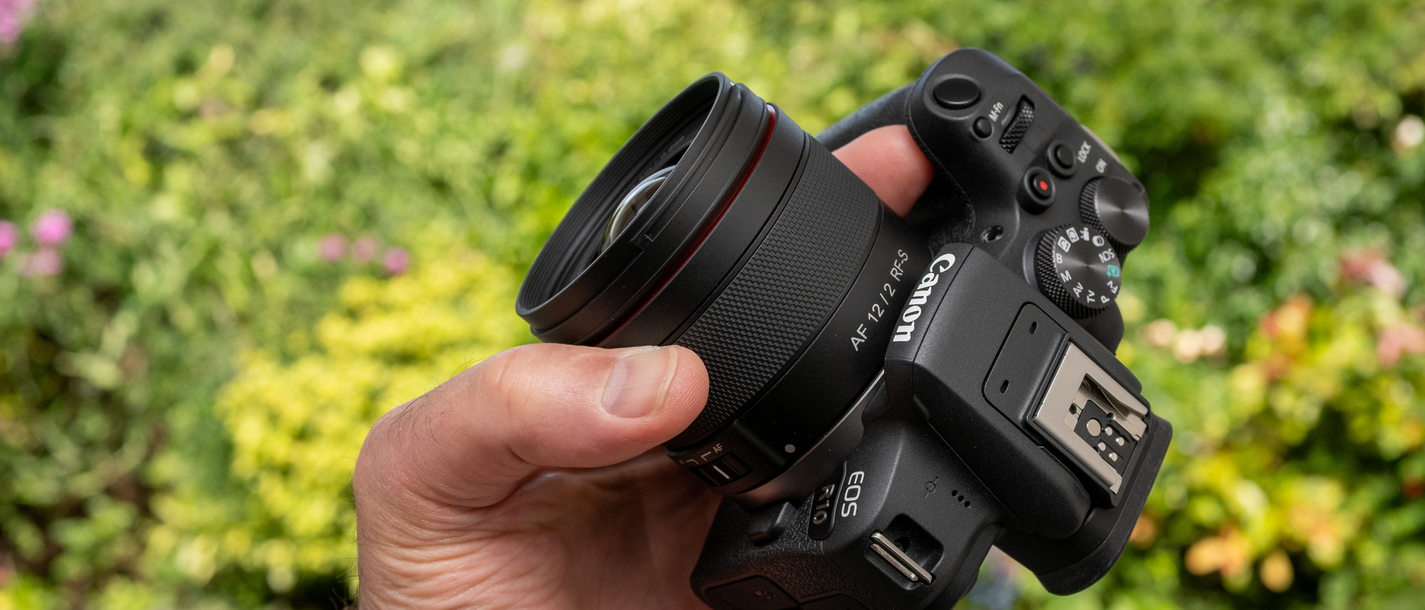 LK Samyang AF 12mm f/2 RF-S product shot lens held in hand
