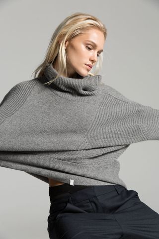 Model wearing grey colour turtle neck woolen top