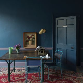 indigo blue wall with blue door and table with chair