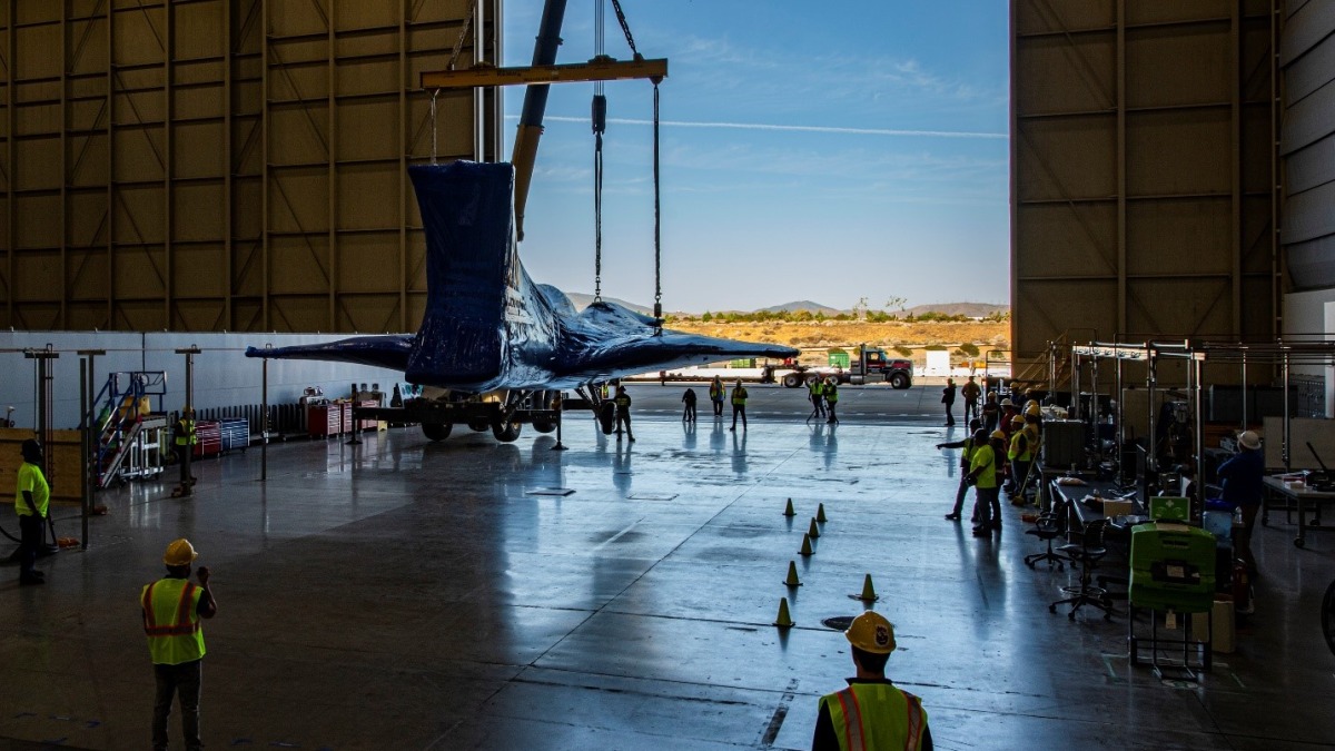 The X-59 is lowered to the ground at Lockheed Martin's Skunk Works facility in Palmdale, California following a crane operation to remove it from the back of its transport.