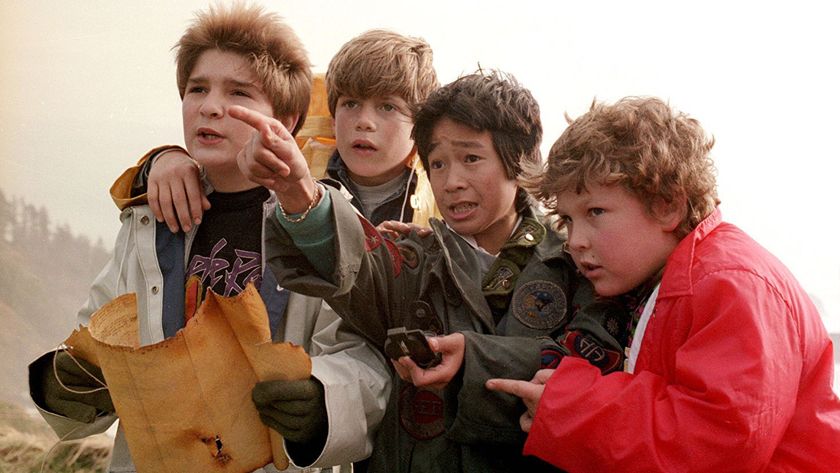 A still from the movie The Goonies, one of the best new HBO Max movies, in which all the main child stars are looking at a map and pointing off camera.