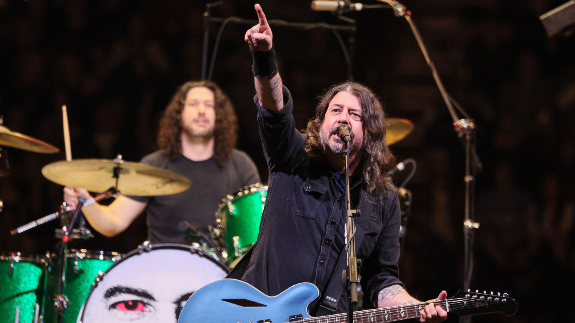 Dave Grohl points towards the crowd while performing onstage during a Foo Fighters benefit concert 