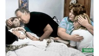 Family grieving at the bed of an ill man