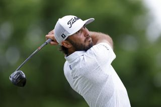 Max Homa strikes an iron shot and watches its flight