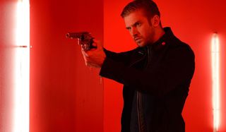 Dan Stevens aims his gun in a fun house in The Guest