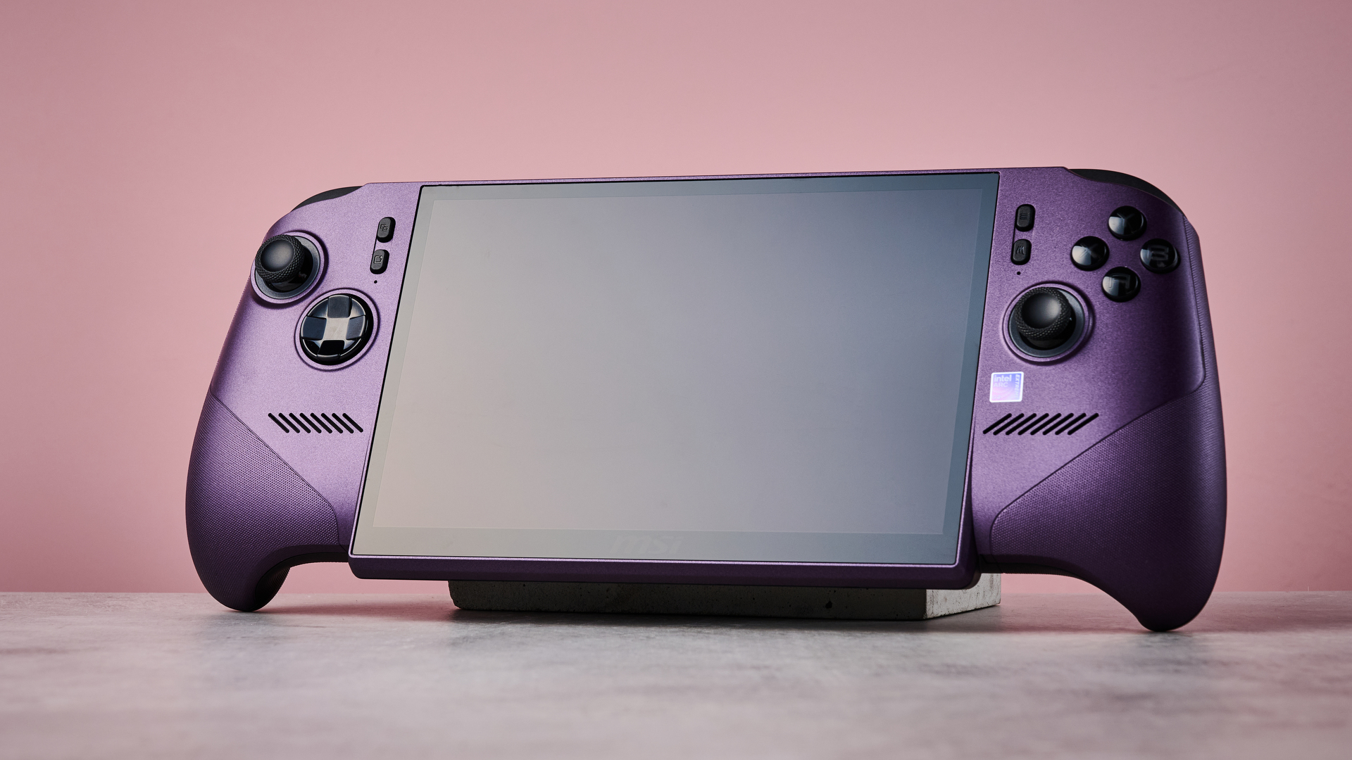 The MSI Claw 8 EX AI+ with its screen off in front of a pink background.