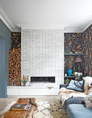 Living room with white brick fireplace, dark grey wallpaper and berber rug