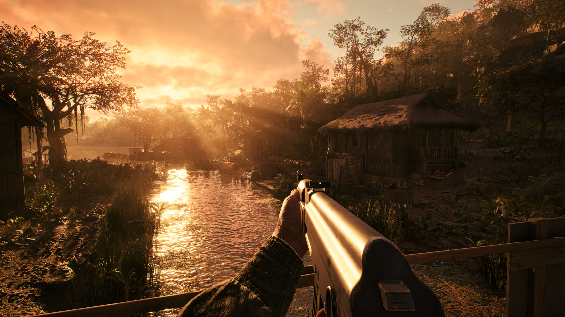 The orange glow of sunset pokes through the treeline as a player looks out across a glistening river in Hell Let Loose: Vietnam