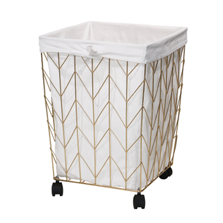 A gold and natural canvas laundry hamper on wheels