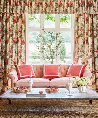 Large window curtain ideas with floral patterned curtains with a valance behind a sofa with pink cushions