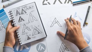 A designer works with sketches of a logo design