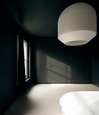 Dark painted bedroom at Concrete Plinth House by DGN studio