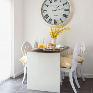 dining area with watch on wall and dinning table and chairs