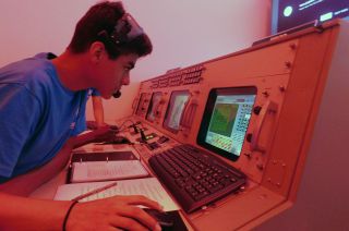 A student takes part in a simulation at the Cosmosphere in Kansas using a modified Apollo mission control console.