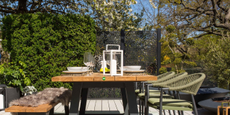 outdoor dining area with table, bench, and three chairs