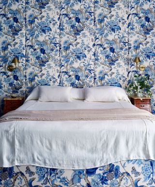 bedroom with full width blue fabric headboard and white bedding