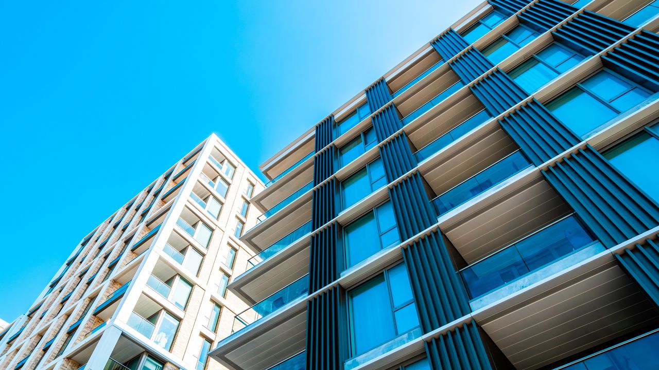 Looking up at an apartment building with a very blue sky as the background.