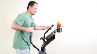 How to use an elliptical machine: middle-aged man working out on a cross-trainer