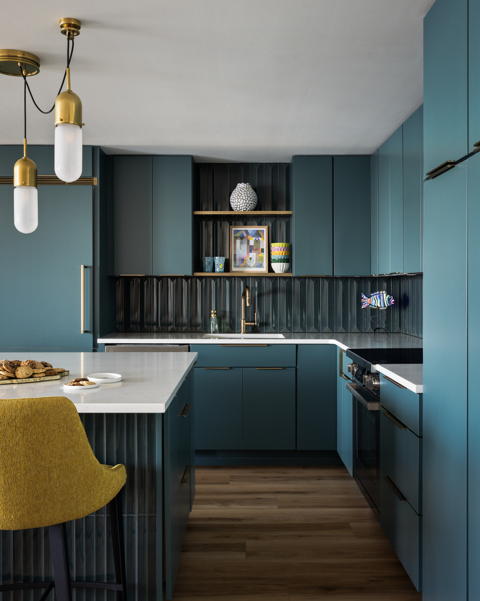 a blue kitchen with high-shine, fluted tiles and gold hardware