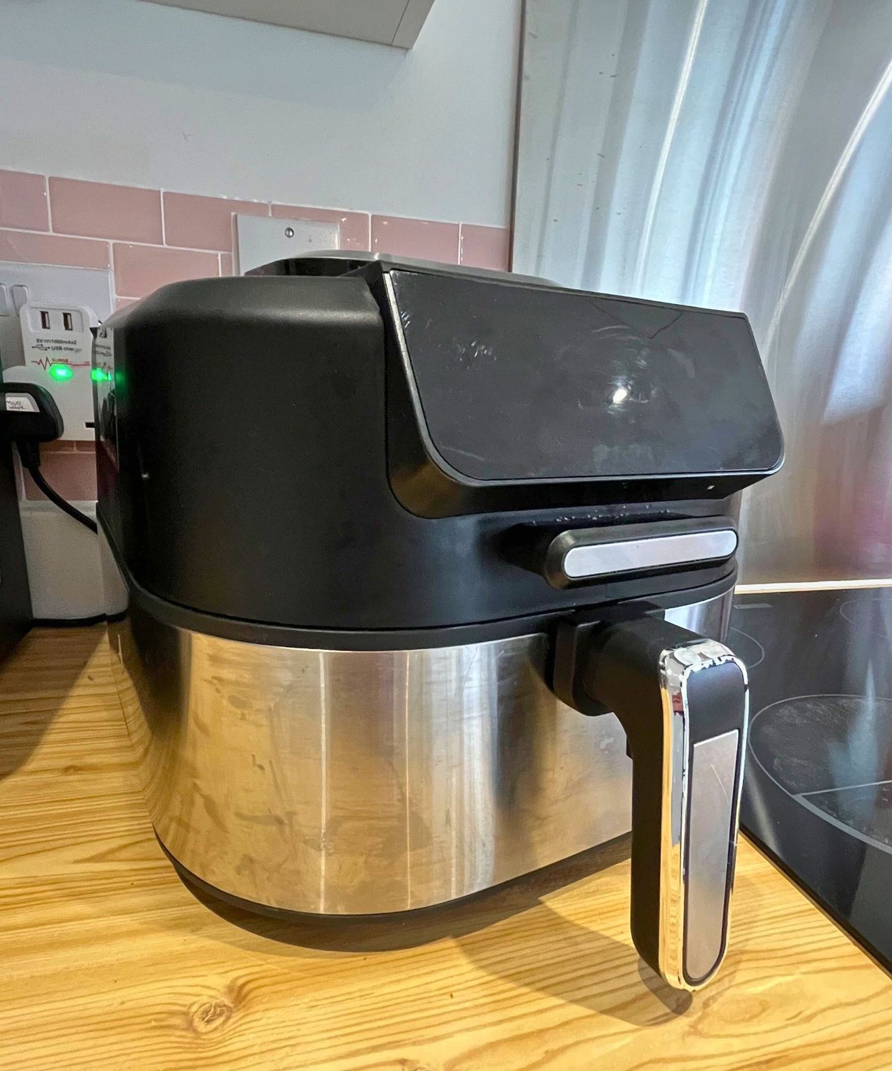 Before image of black air fryer with stainless steel lower half that has grime and streaks