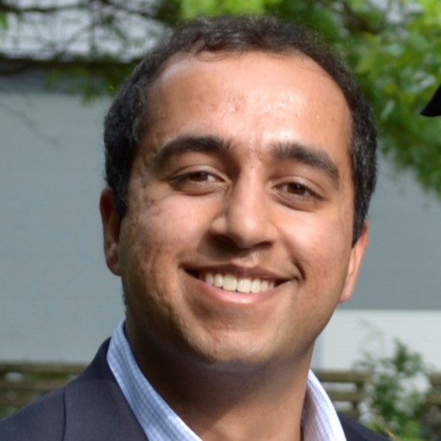 A headshot of a man smiling at the camera