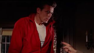 James Dean wearing a white tee shirt and red leather jacket in Rebel Without A Cause