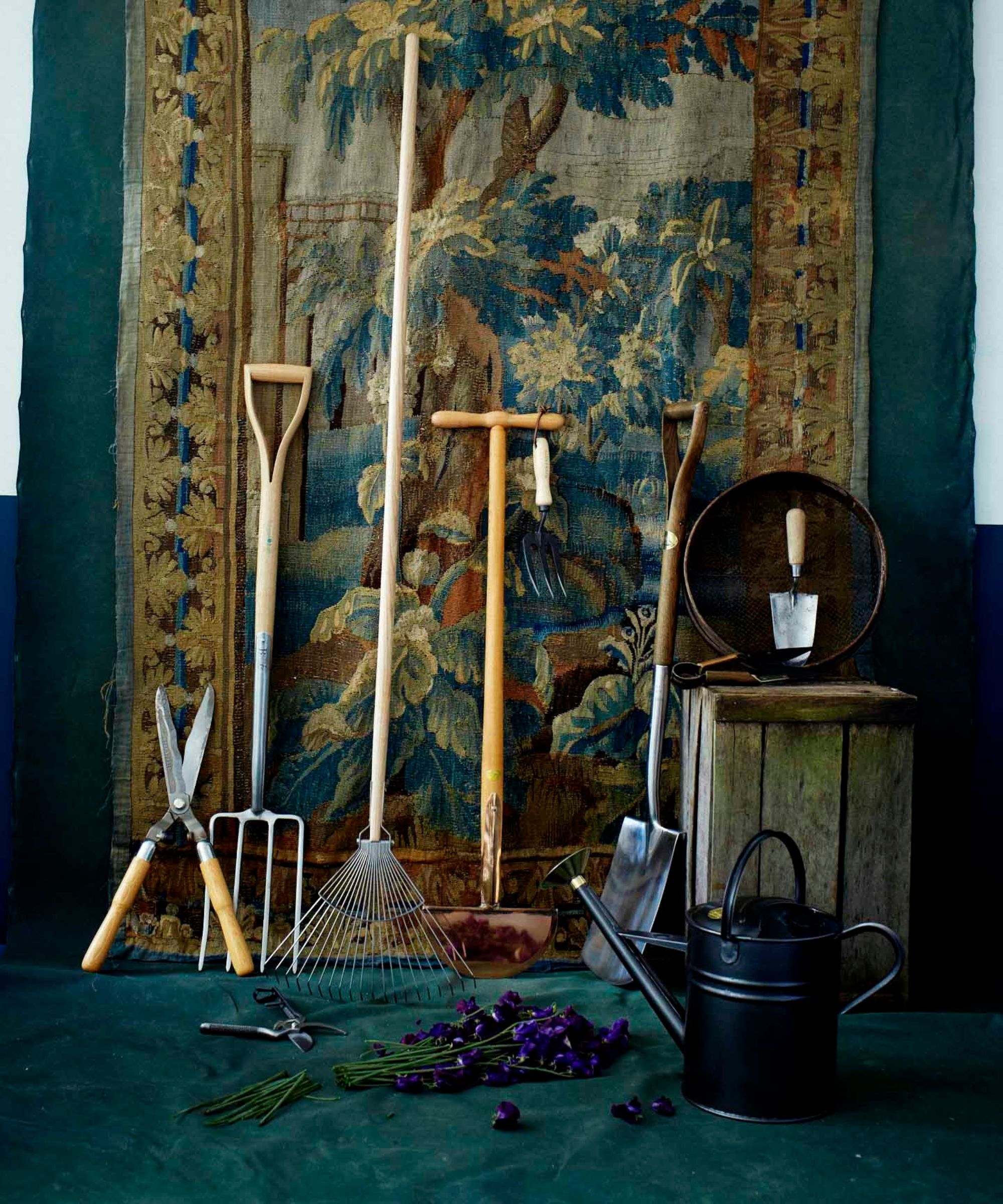 Garden tools resting against an ornate patterned rug