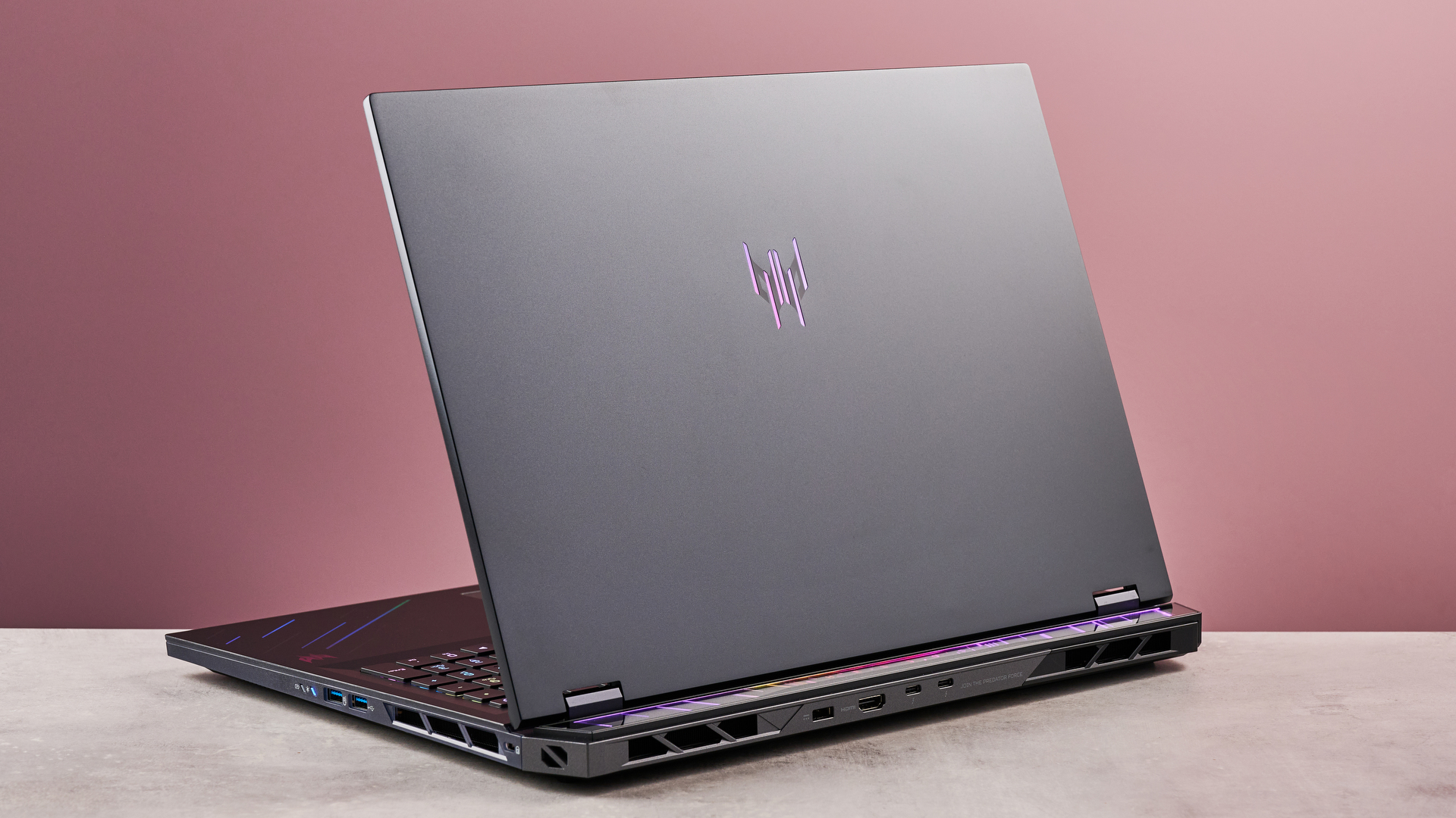 Rear of Acer Predator Helios 18 AI open on desk with pink background