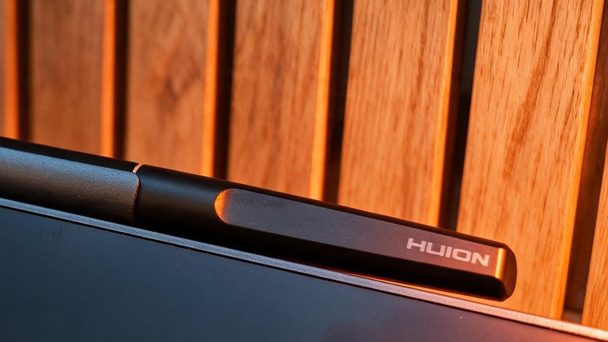 A black drawing tablet on a wooden desk