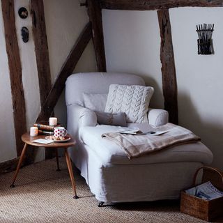 room with armchair and side table and beams