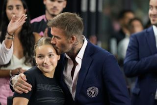 David Beckham kisses his daughter Harper as they attend the team's Leagues Cup soccer match against Orlando City