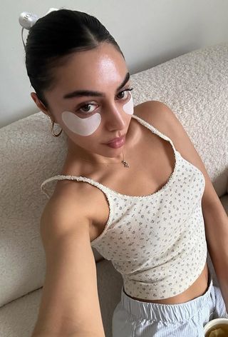 Content creator Mobina Peiman poses with dewy skin and under eye patches.