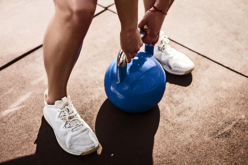 Closeup of hand holding the handle of a kettlebell