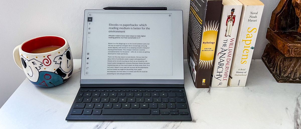 reMarkable 2 in keyboard folio on a table with a cup and books