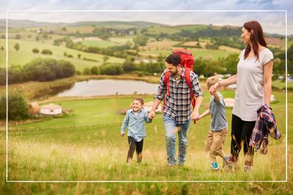 Parents with two children walking up a hill in the British countryside