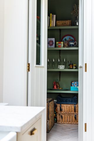 white pantry with green shelves in small kitchen