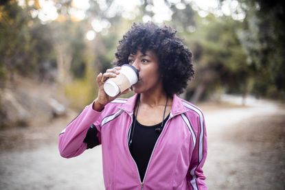 A young black woman with a coffee before a workout
