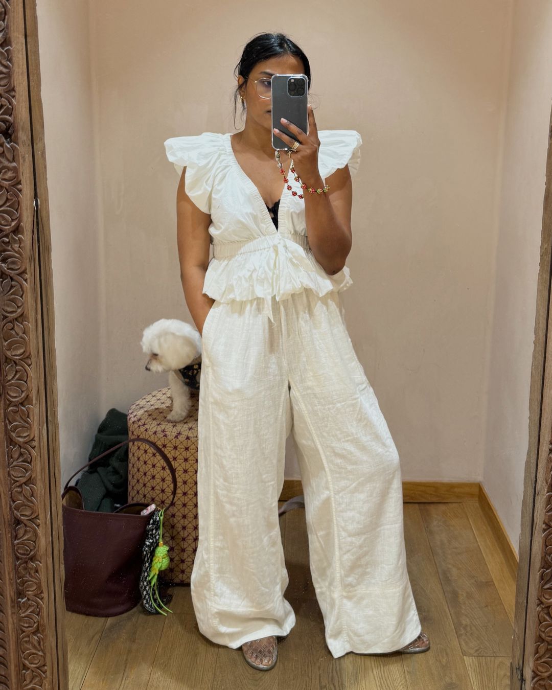 @chiarasatelier wears white linen trousers from Free People with a white short-sleeved blouse
