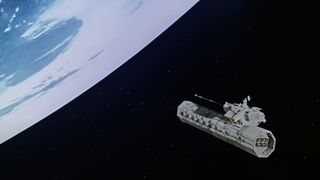 a cylindrical spacecraft approaches a blue and white planet