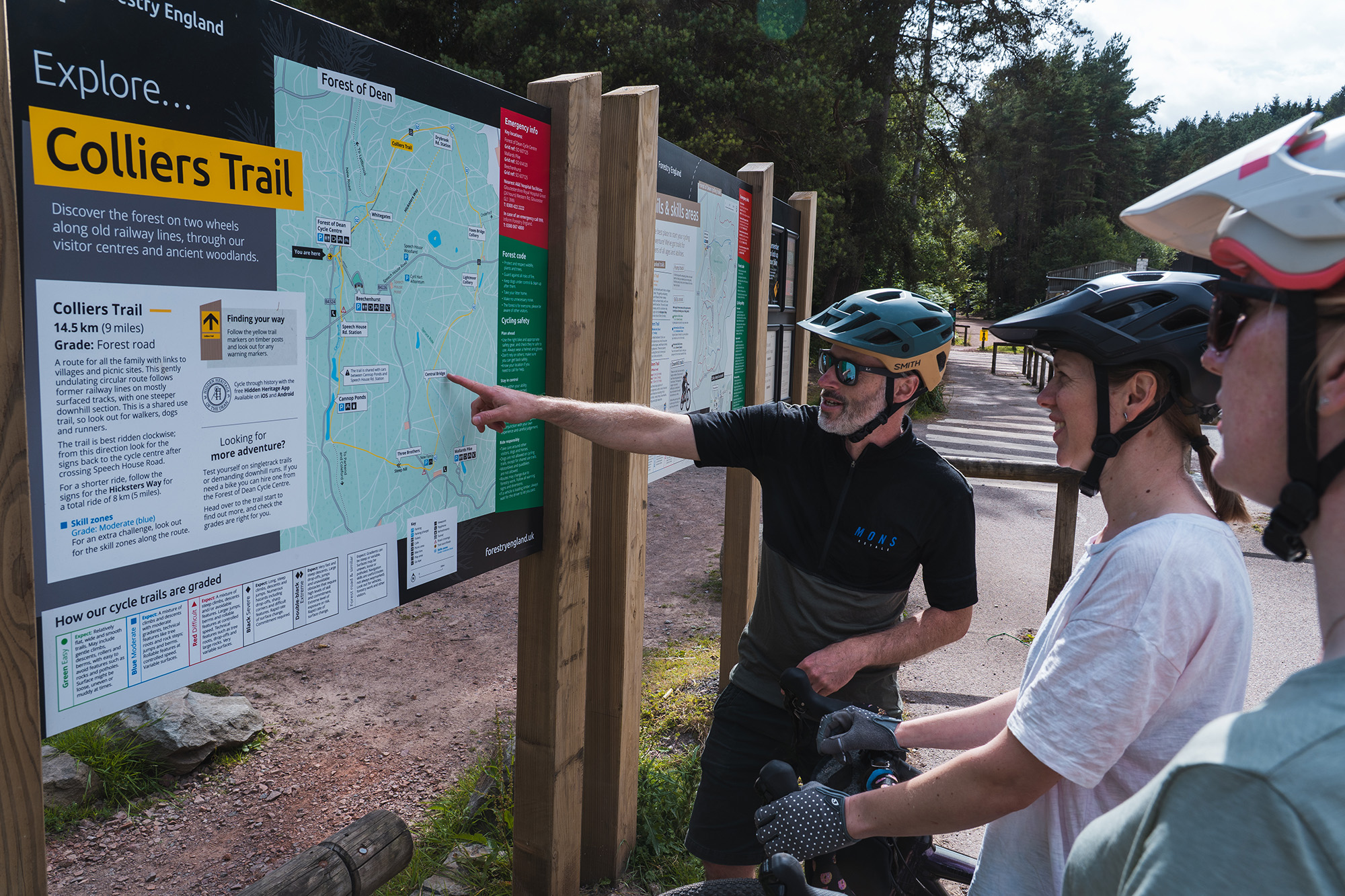 Cyclists studying a route board in the Forest of Dean