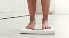 Women weighing herself on scales