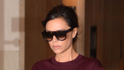 Victoria Beckham wearing burgundy top with grey suit trousers in New York City in 2017