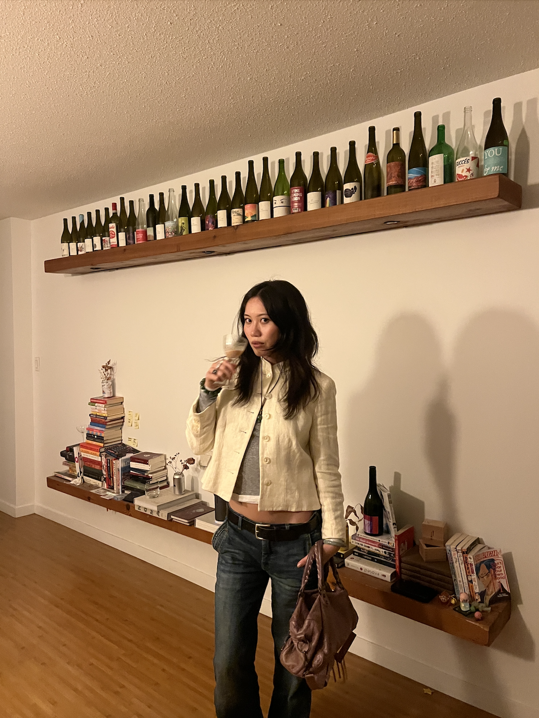 Vivian Li standing in front of two bookcases and a white wall