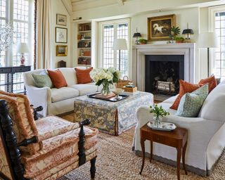 traditional living room with neutral decor with dark orange and teal pillows on sofas