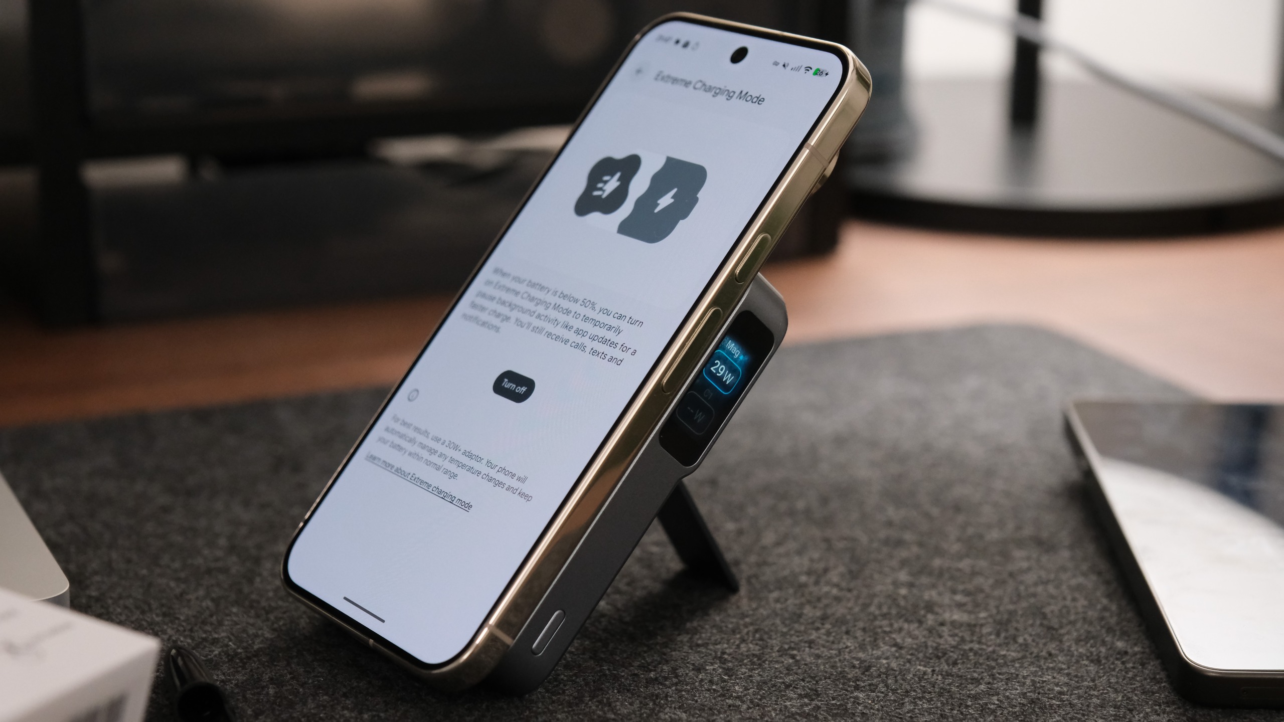 Smartphone mounted on the Anker MagGo Power Bank 2 Pro using its kickstand, with the phone displaying Extreme Charging Mode settings.
