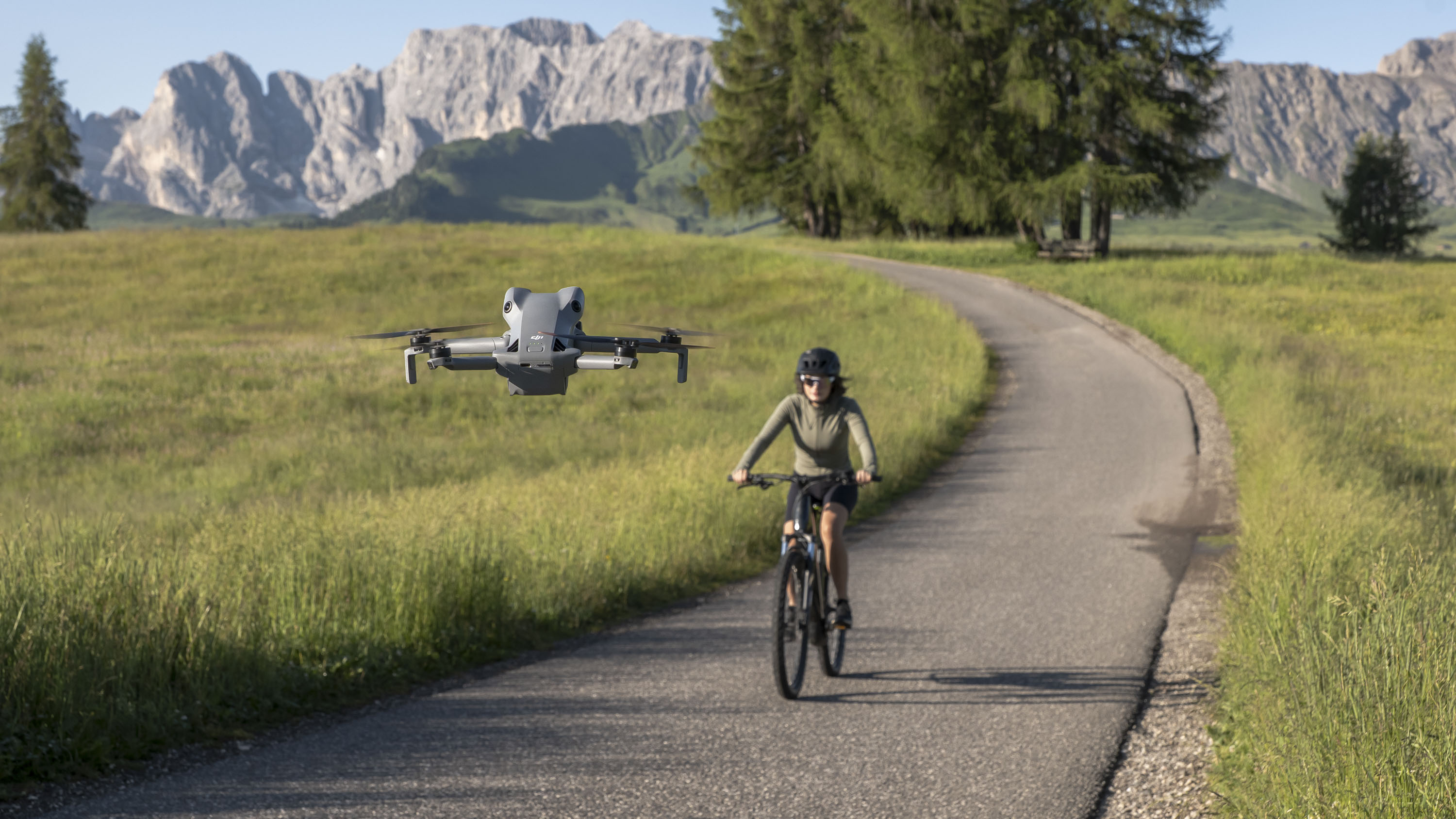 DJI Mini 5 Pro drone in flight tracking a lady cycling on a road