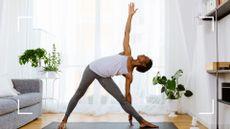 woman stretching upward, doing yoga for beginners in living room next to plants, using yoga mat
